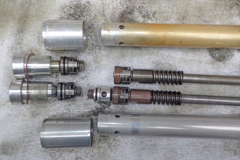 Micro close-up comparison of the compression base valves and shim stacks between MD30 and ME08 front forks.