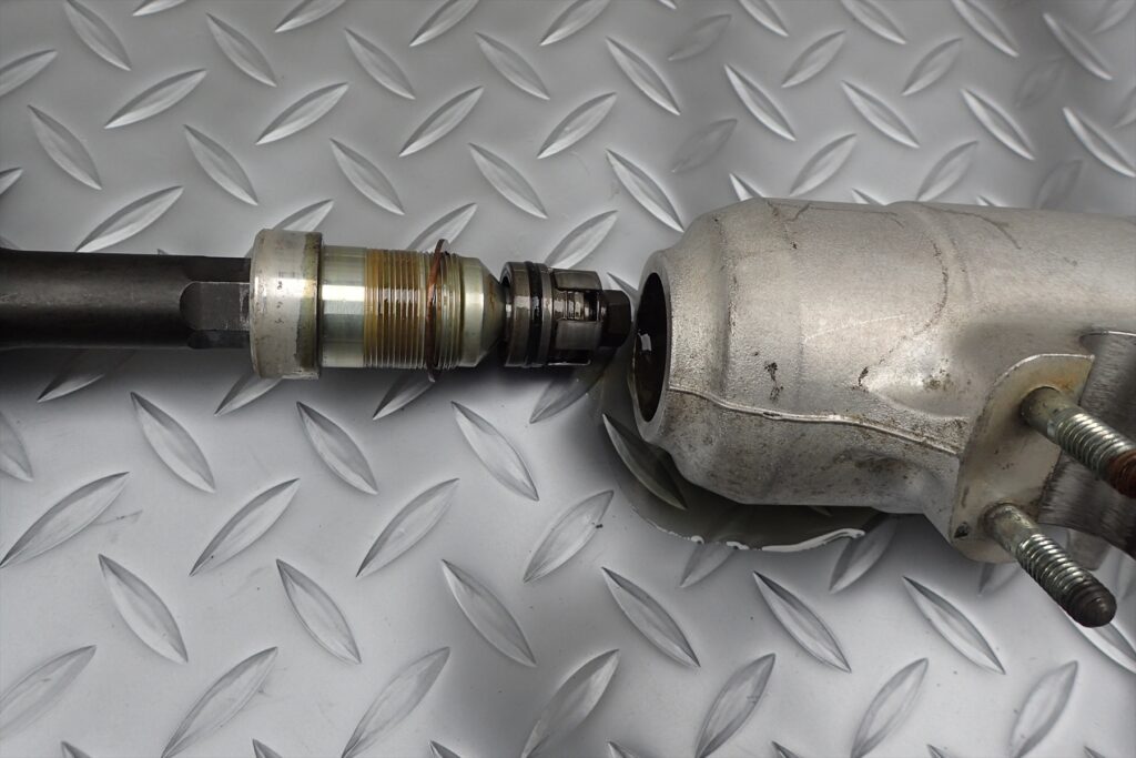 Extracting the bottom base valve assembly from the lower end of a motorcycle front fork slider.