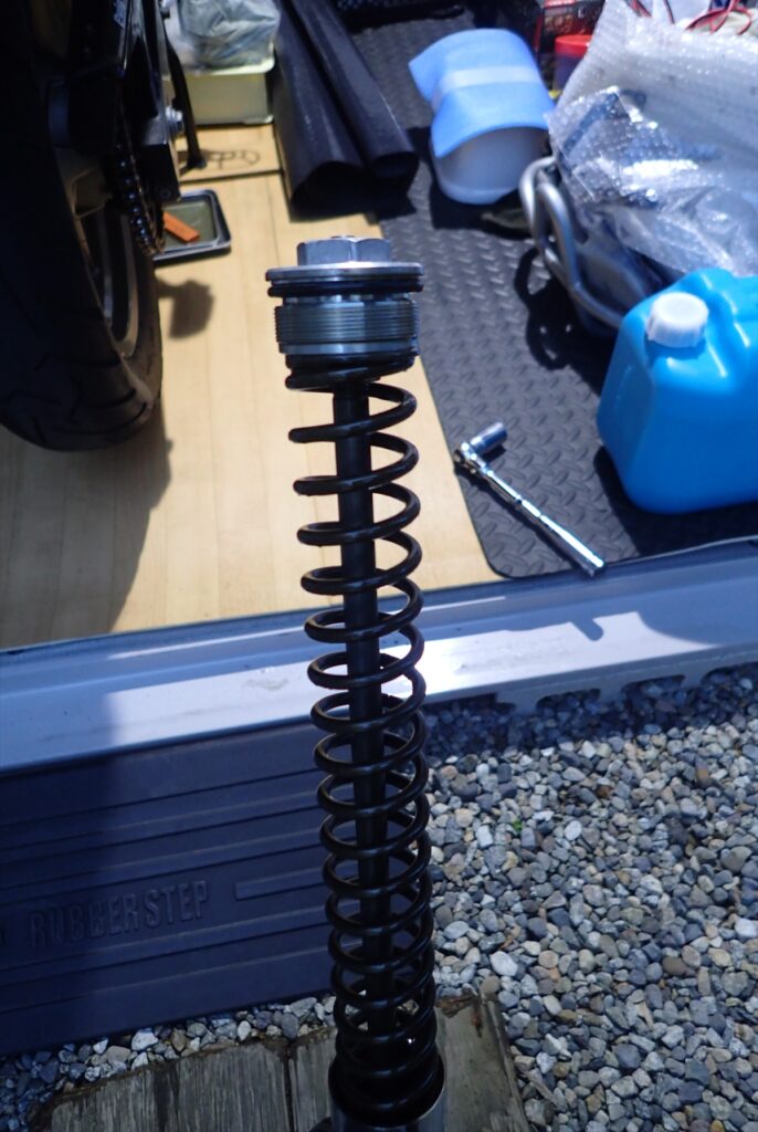 Pulling out the inner rod and fork spring from the motorcycle front fork for inspection.
