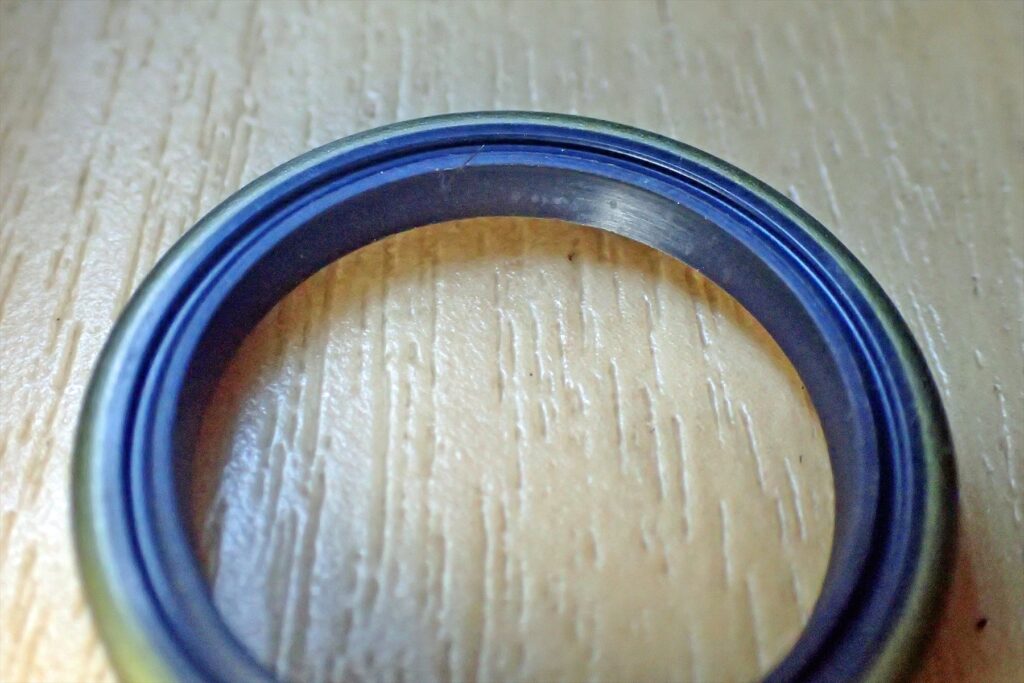 刻印がない側のオイルシールを斜めから撮影。リップの深さと異物侵入防止およびグリース保持のための形状詳細。