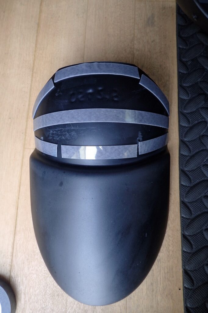 Multiple rows of strong 3M double-sided tape applied horizontally to the fender extender to block mud and water entry.