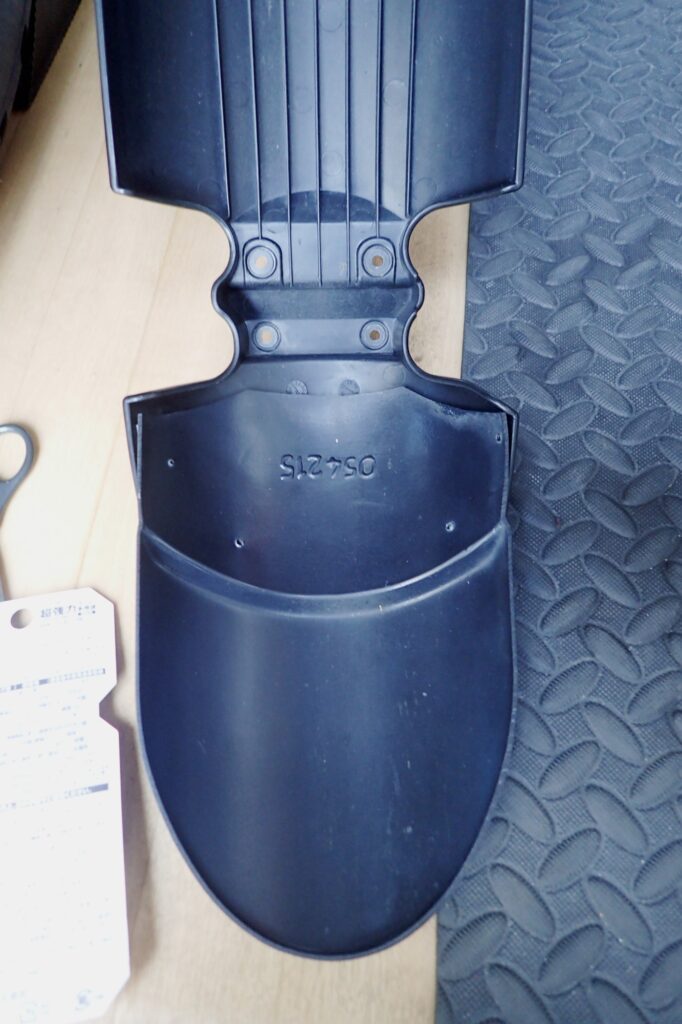 An inner view of the assembled BMW G650GS front fender, aligning the screw holes of the extension flap.