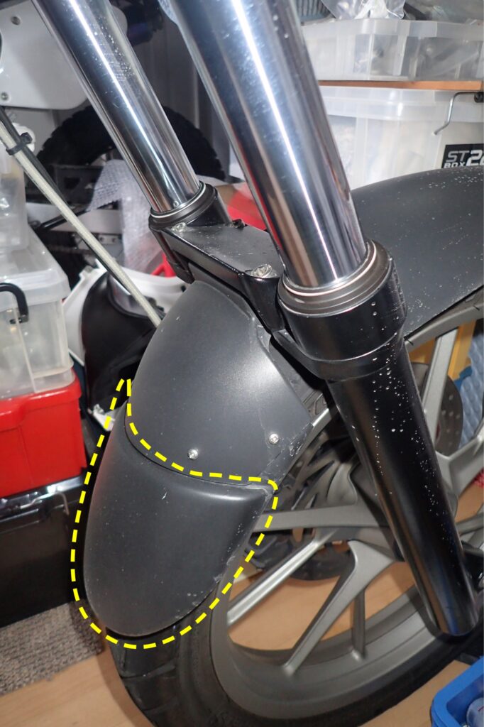 Front view of a BMW G650GS motorcycle showing a misaligned front fender extender mudflap crookedly installed with screws.