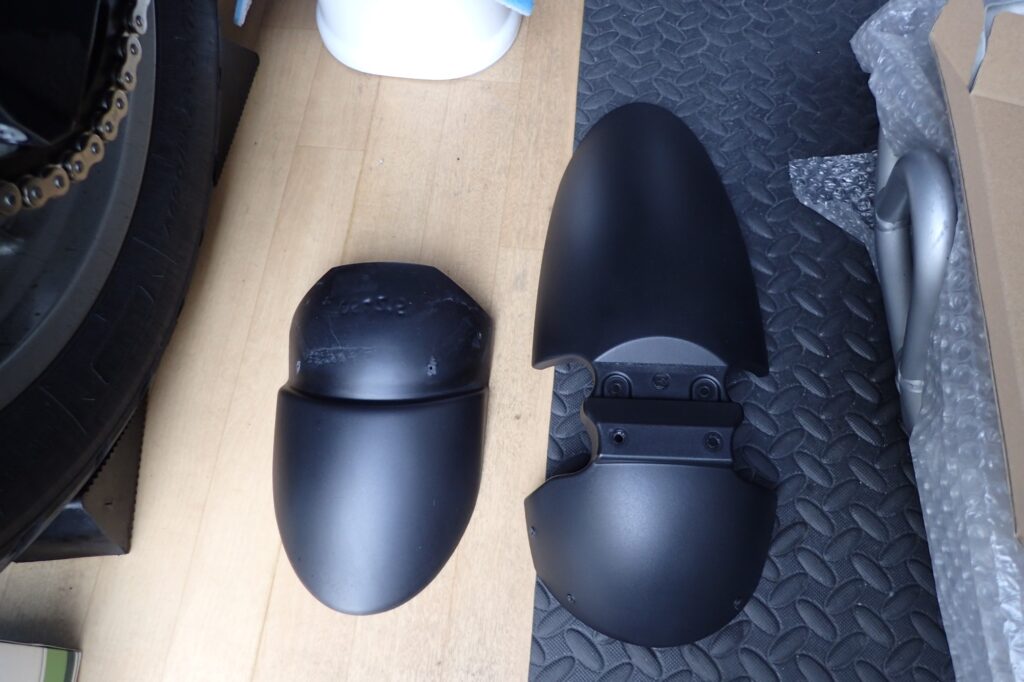 The original black front fender and cleaned extension flap of a BMW G650GS motorcycle, completely ready for reinstallation.