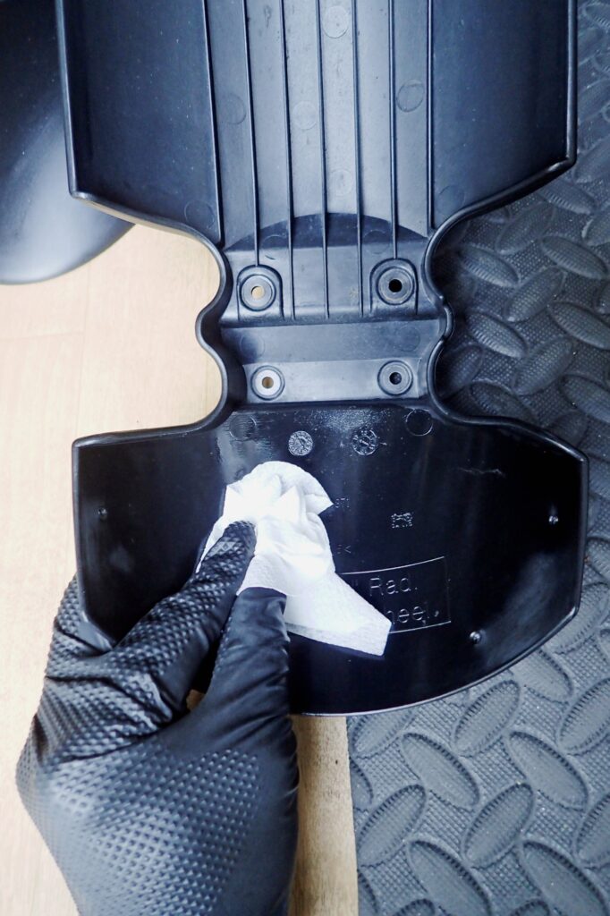 Carefully cleaning and degreasing the inner side of the original BMW G650GS front fender using a paper wiper.