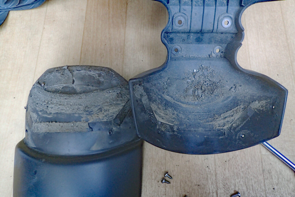 The front fender extender separated from the main fender, revealing a thick layer of trapped mud and dirt crust on the overlapping surface.