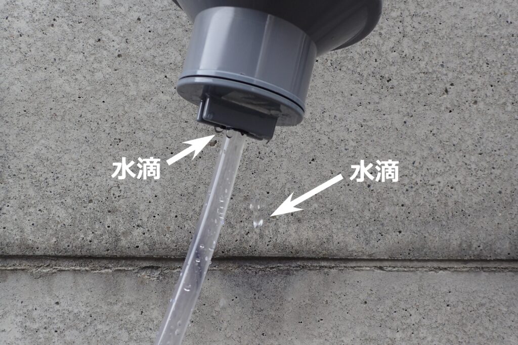 重曹ブラスト用に自作した塩ビパイプ製の供給容器に水を入れると、塩ビパイプと透明ホースの結合部から水が漏れている様子。