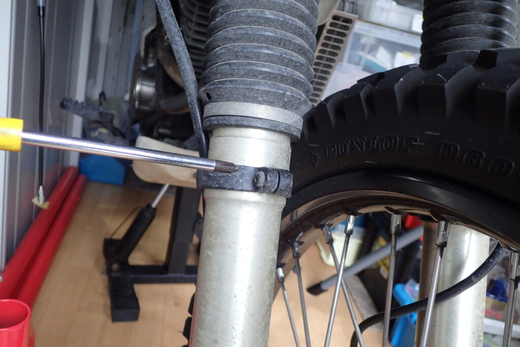 フロントフォークとスピードメーターケーブルの固定バンドを外す