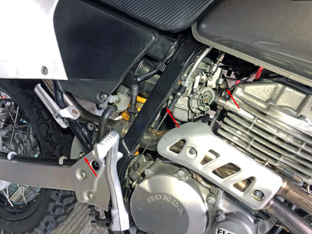 NGCスムーズドライブ(静電気除去システム)が取り付けられたホンダ XR250 のエンジンとキャブレター周りの詳細写真です。インシュレーターバンドボルトやステップホルダー、その他複数の除電ボルトが確認できます。このシステムにより、吸気効率の向上やエンジントルクの増大といった効果が期待されます。