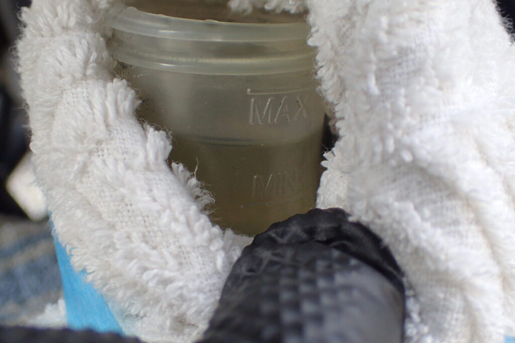 リアブレーキタンクのフルード量を確認する.