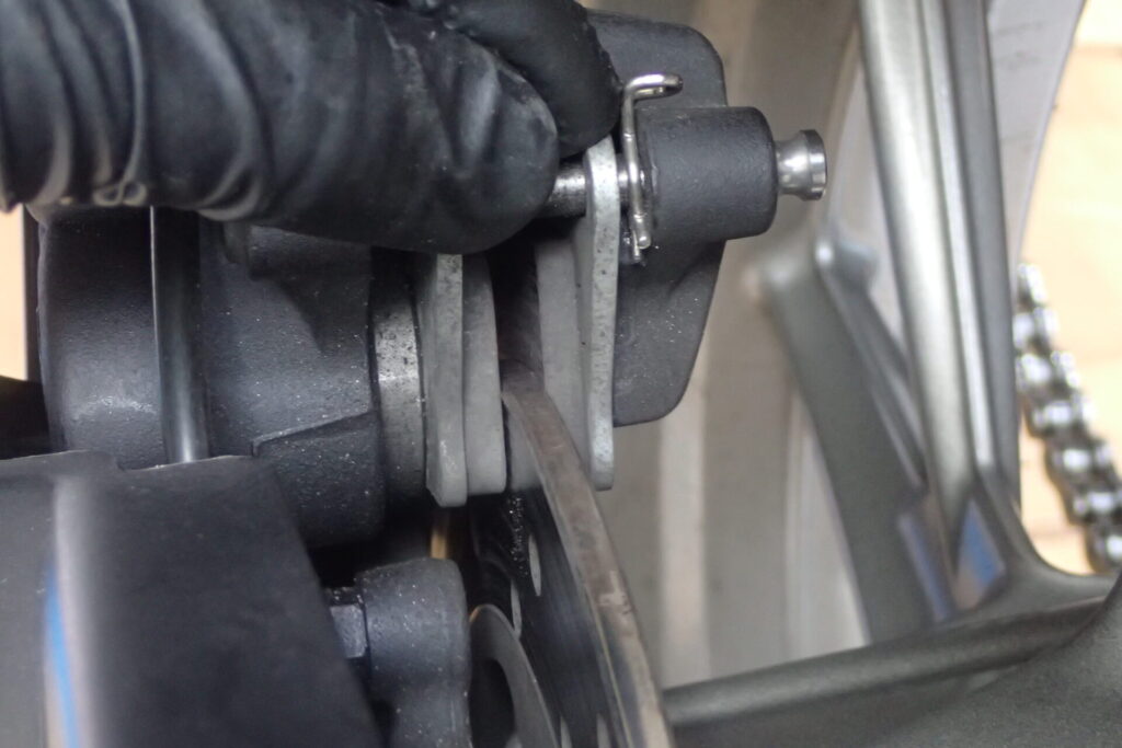 リアタイヤを外すために,リアブレーキパッドを少し広げて,ブレーキディスクを外すところ.