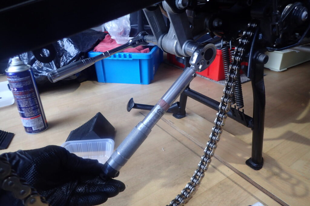 スイングアームとリアリンクの取り付け部をトルクレンチによって締めているところ.