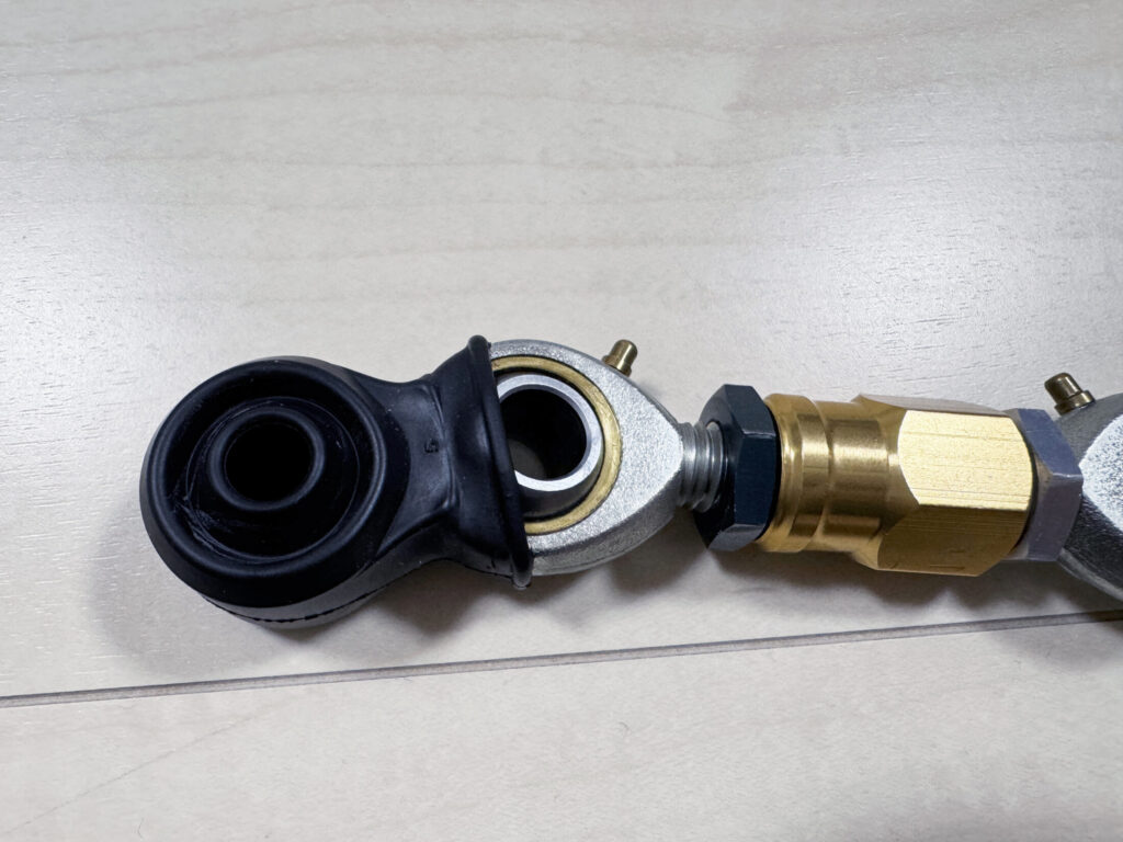 柔軟性のあるIKOダストカバーを伸ばしながらantlion車高調整キットのベアリング部に被せる作業の様子