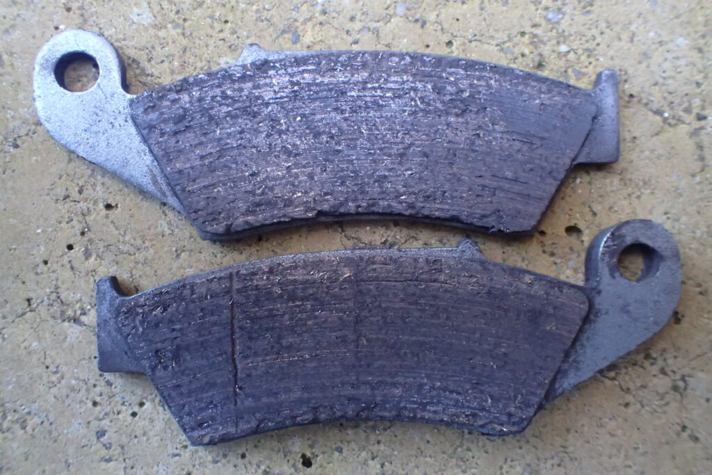  摩耗した古いブレーキパッド。斜めに当たっていた摩耗の様子。