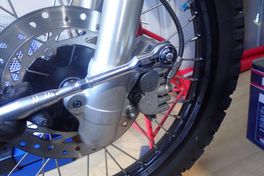 【キャリパー外し】 車体から取り外したブレーキキャリパー。ピストンが押し出された状態を確認する。