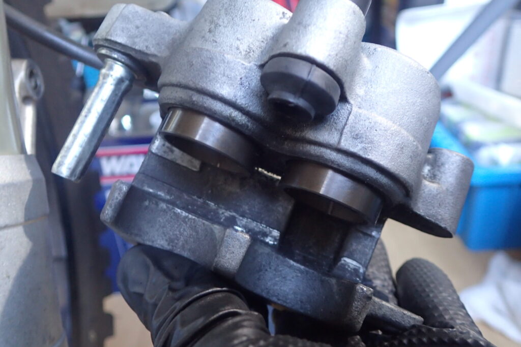 【ピストン清掃】 ブレーキキャリパーピストンの清掃方法。ブラシやツールを使ってピストン全周の汚れを落とすメンテナンス。