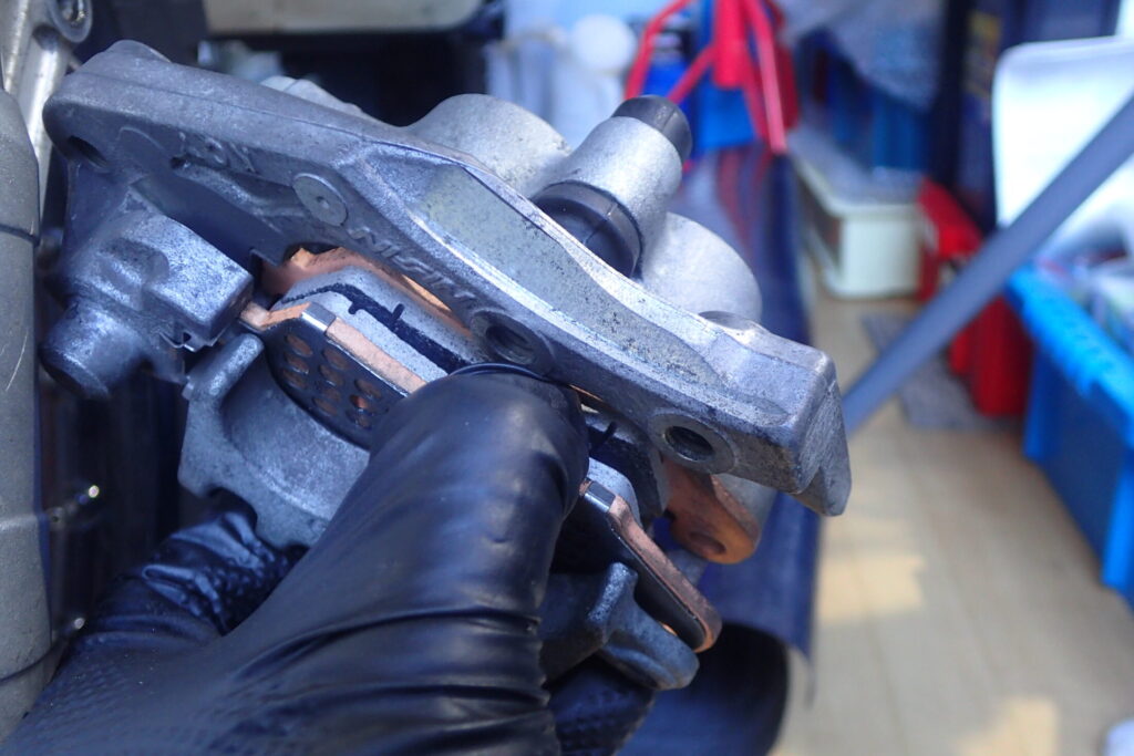 【パッド装着】 デイトナ ゴールデンパッドχ（新品）をブレーキキャリパーに取り付けた状態。キャリパーを車体に戻す前の確認。