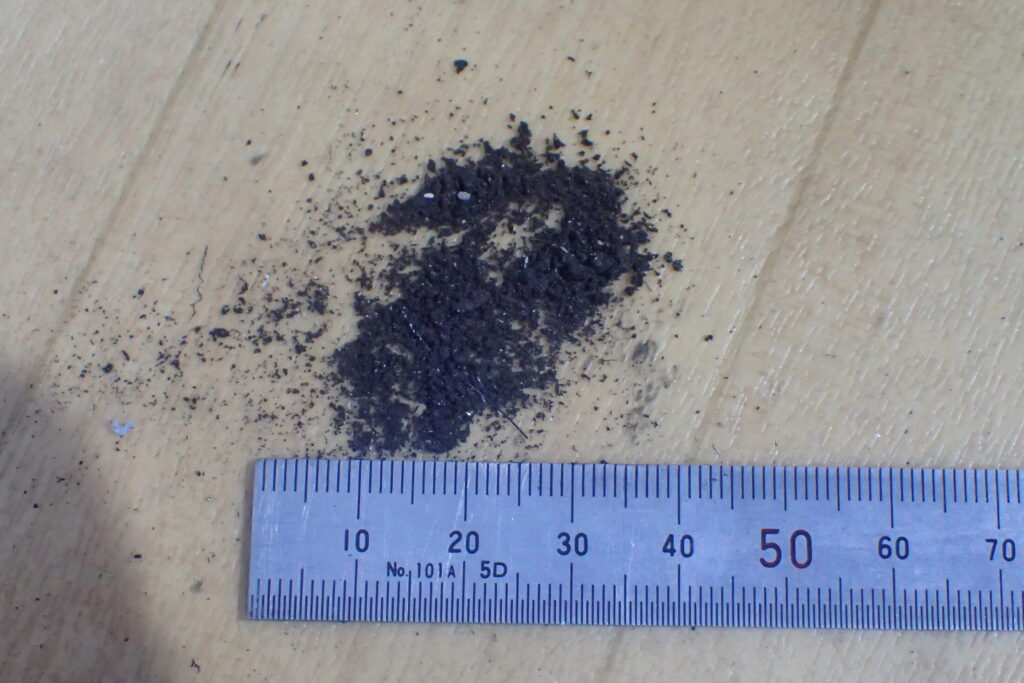 【清掃後の汚れ】 ブレーキキャリパーとピストンから除去された汚れ。定期的なメンテナンスの重要性を示す。