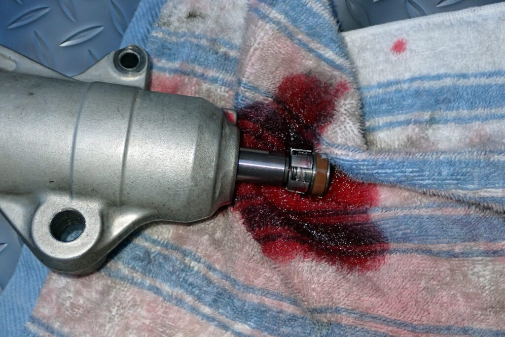 XR250 BAJAのフロントフォークを分解し，ピストンロッドを外している様子．