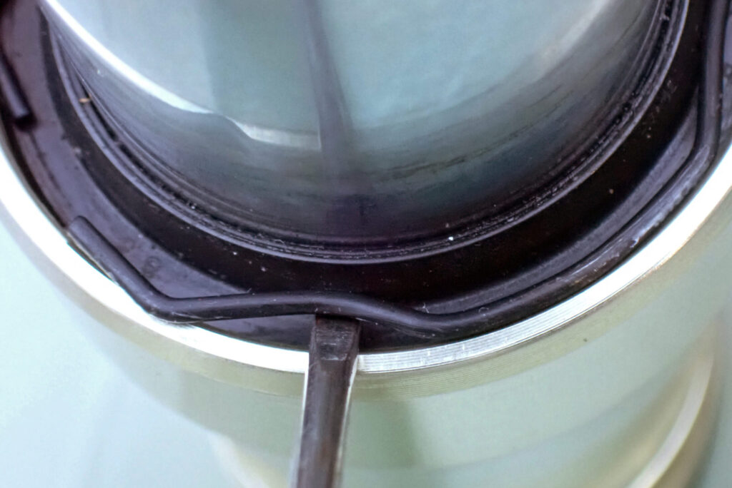 マイナスドライバーを使用したダストシールとスナップリングの取り外し作業