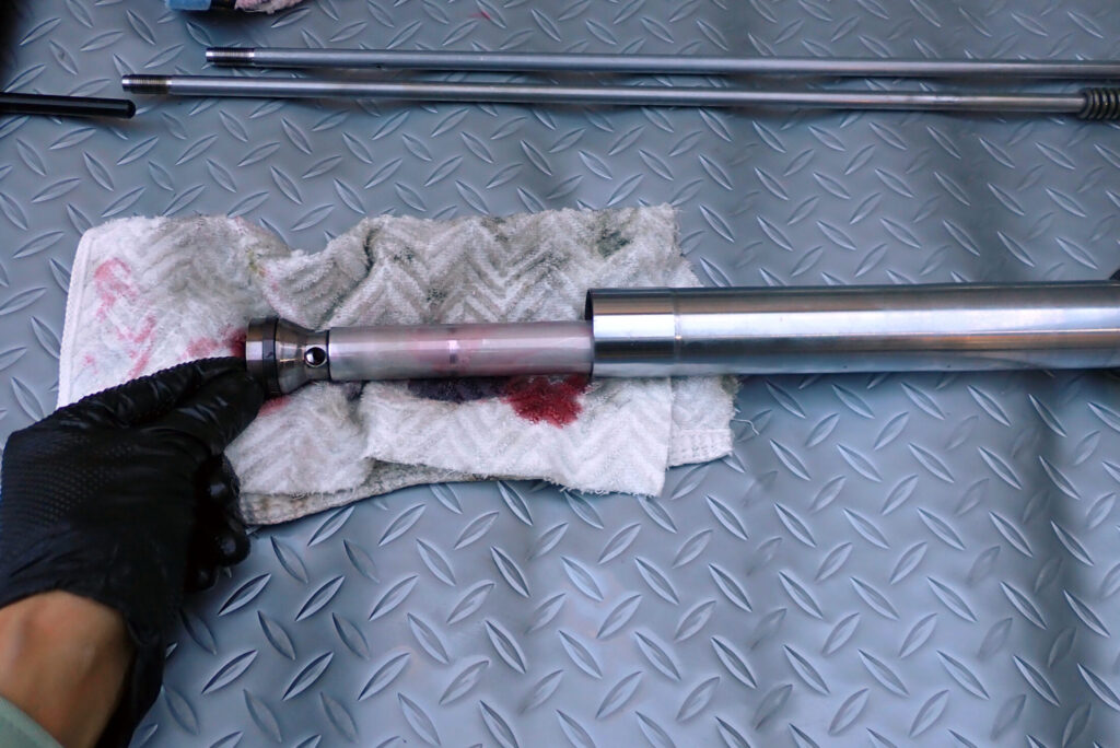 XR250 BAJAのフロントフォークを分解し，フォークダンパを外している様子．