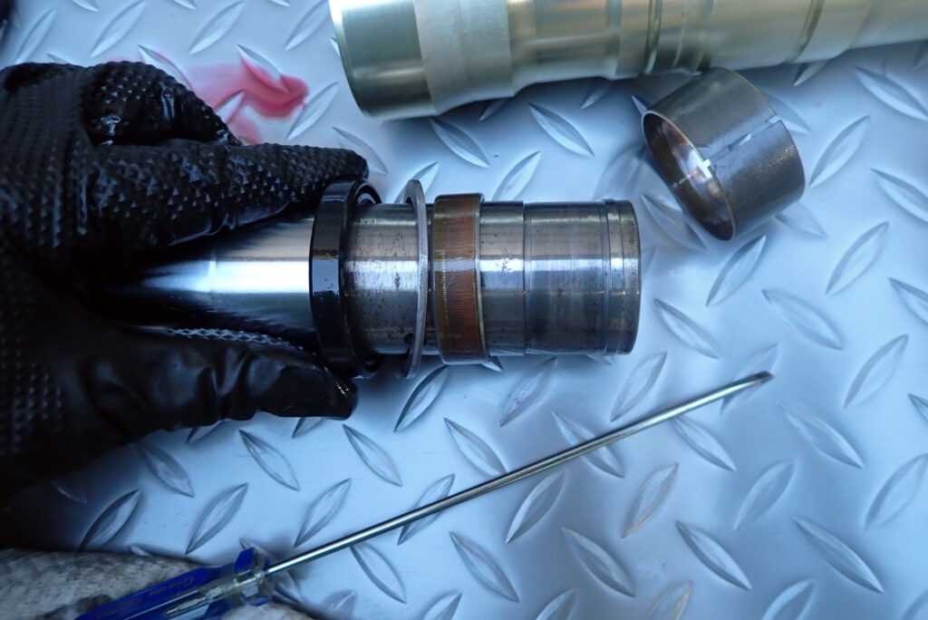 インナーチューブからガイドブッシュ，バックアップリング，オイルシールを外す様子．