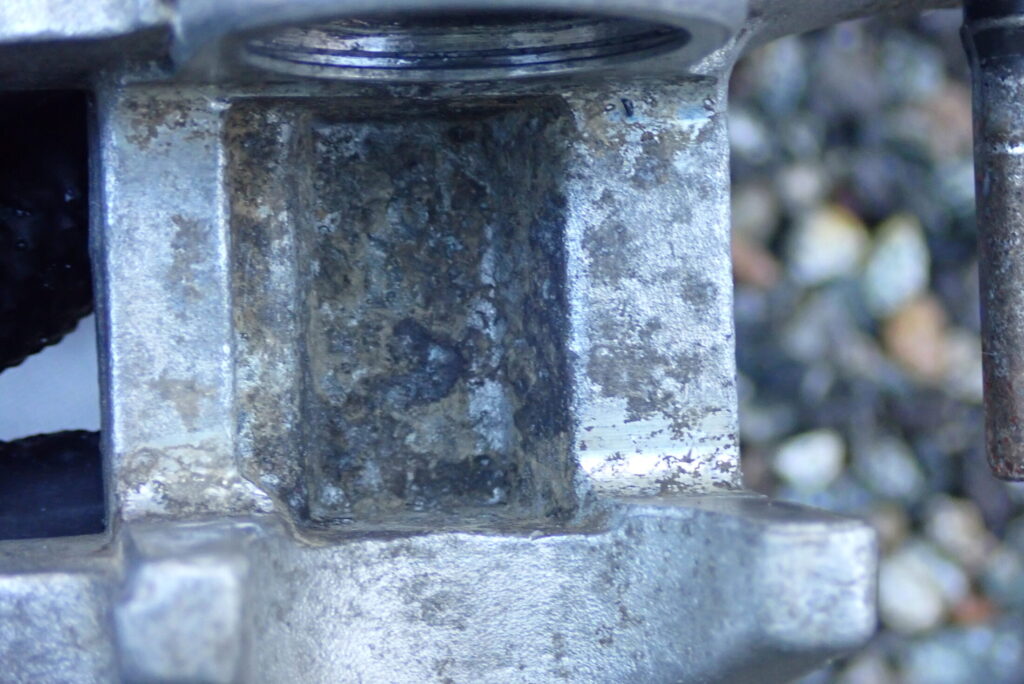 ウェットブラスト施工前の、白サビや腐食が目立つ古いバイク（XR250 BAJA）のリアブレーキキャリパー