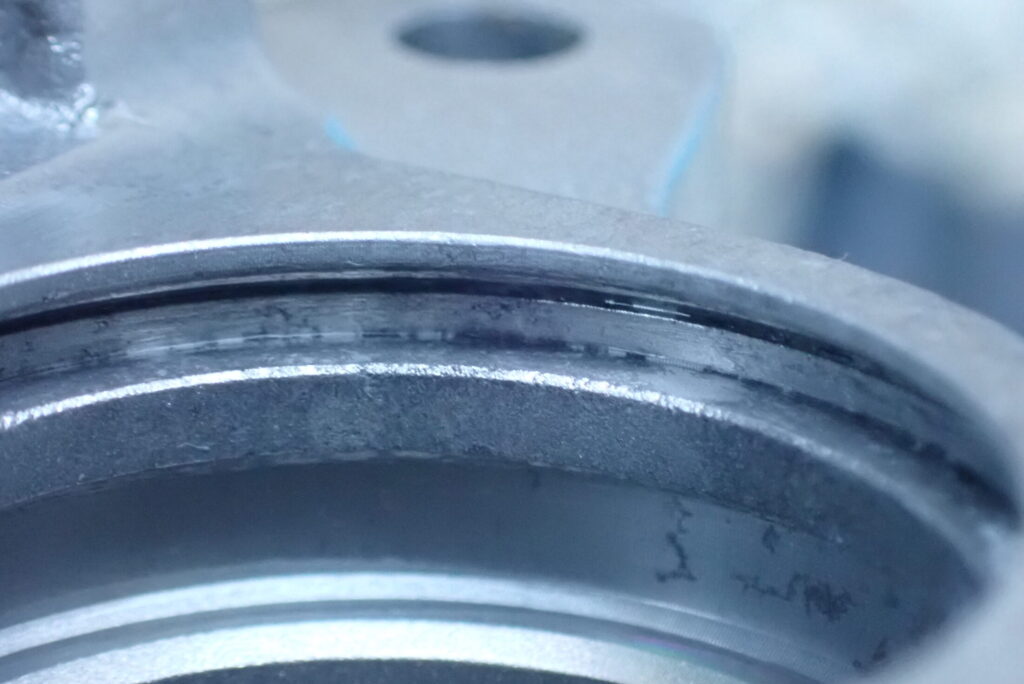 ウェットブラスト施工後の、バイク（XR250 BAJA）のリアブレーキキャリパーのシール溝．おおまかな汚れが取れている．