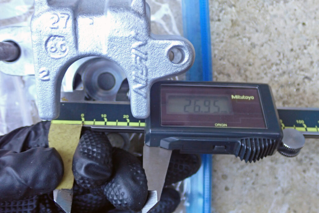 デジタルノギスを用いて測定したXR250 BAJAの純正リアキャリパーのピストン径（26.95mm）の様子。