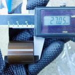 デジタルノギスを用いてXR250 BAJAの純正リアキャリパーのピストンを測定している様子。