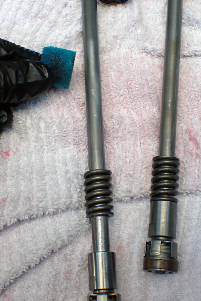 ホンダXR250バハのフロントフォーク組み立て前に、布ヤスリでピストンロッドのサビを落とすメンテナンス作業