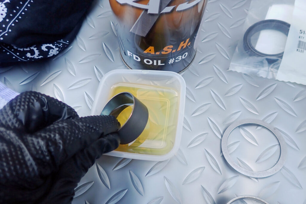 スライドメタル，スライドブッシュにA.S.H.のフォークオイルを塗布する作業風景．