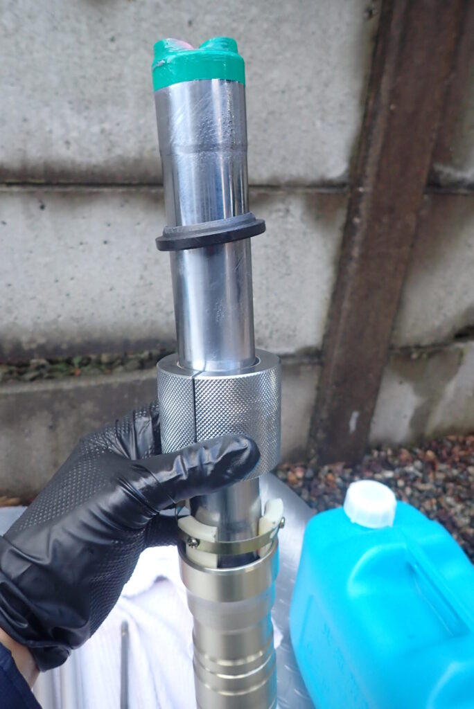 フォークシールプッシャーの重り（ウェイト）をスライドさせて、オイルシールをアウターチューブへ打ち込む様子