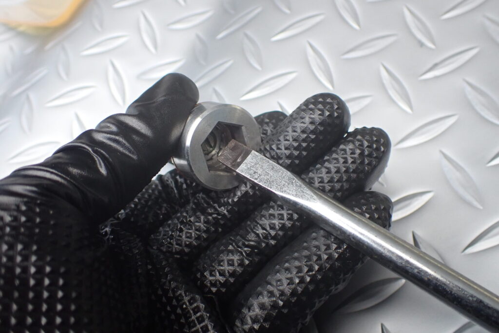 センターボルトの圧側調整機構の調整をしている様子．