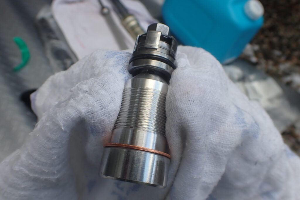 緩みとオイル漏れを防止するため、フロントフォーク底部のセンターボルトにネジロック剤を塗布する前にネジ山を清掃する作業