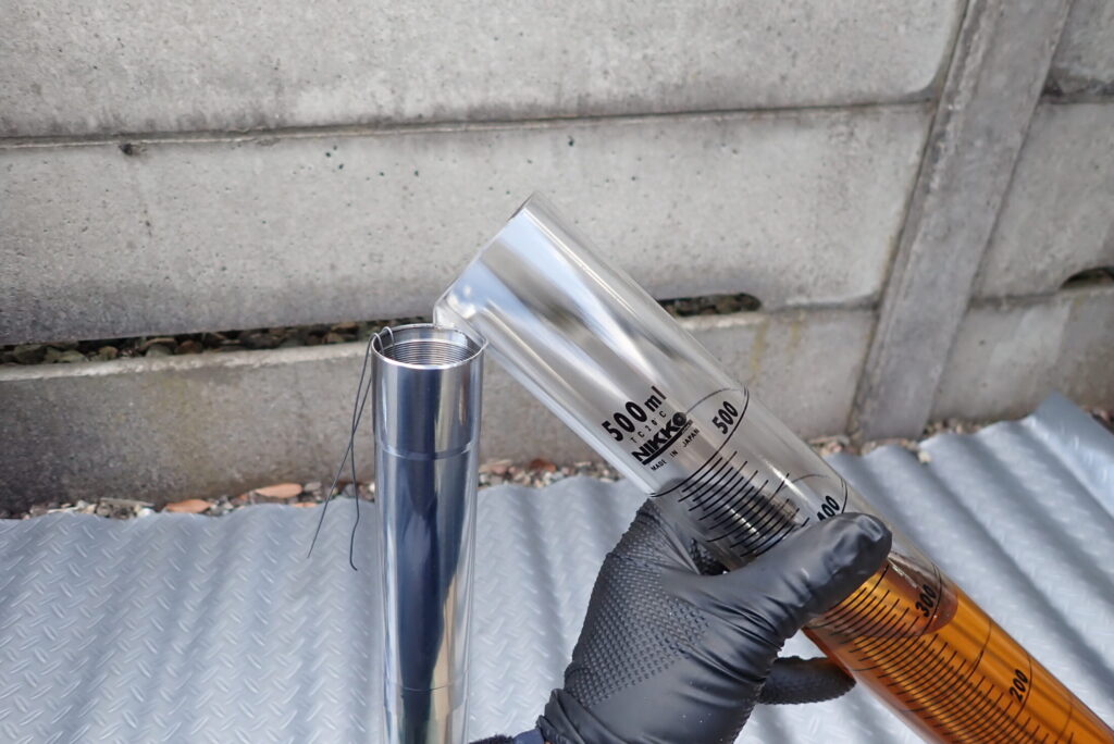 オーバーホール中のXR250 Bajaフロントフォークへ、慎重にフォークオイルを注ぎ入れる作業風景。