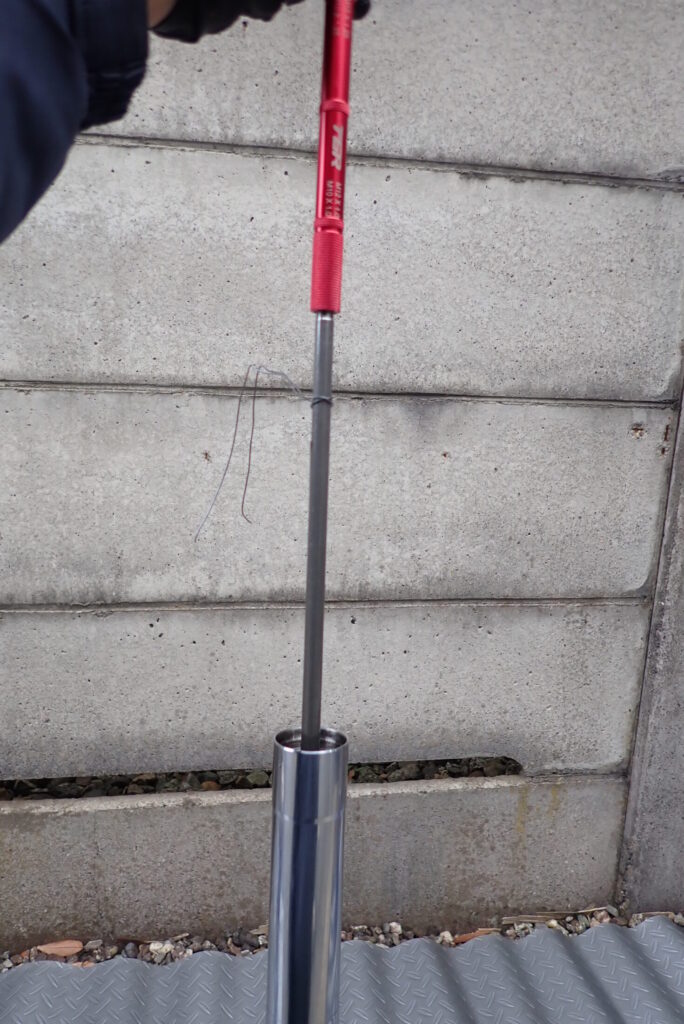 ブリーディングロッドを用いてピストンロッドをストロークさせ、フォーク内部の空気を抜くメンテナンス工程。