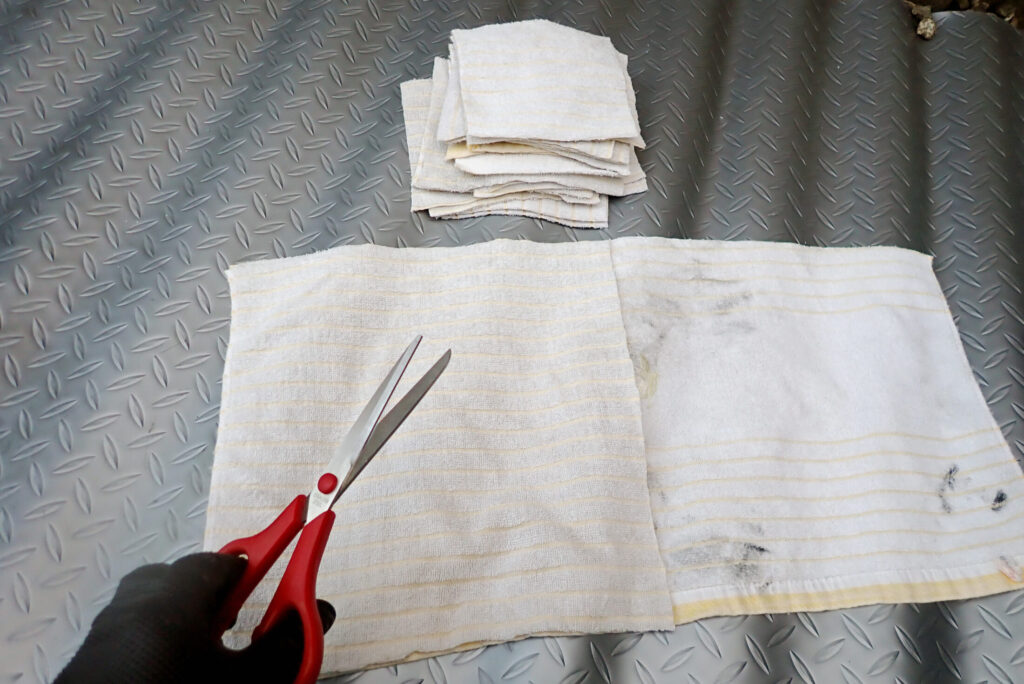 バイクメンテナンス用の自作ウェスを作るために用意した、吸水性の良い使い古しの綿100%バスタオル。パーツクリーナーやオイル汚れの拭き取りに最適な素材選びの様子。
