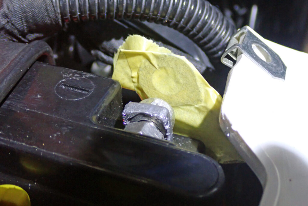 不意な接触を防ぐために確実に養生されたバッテリー端子とハーネスのクローズアップ写真