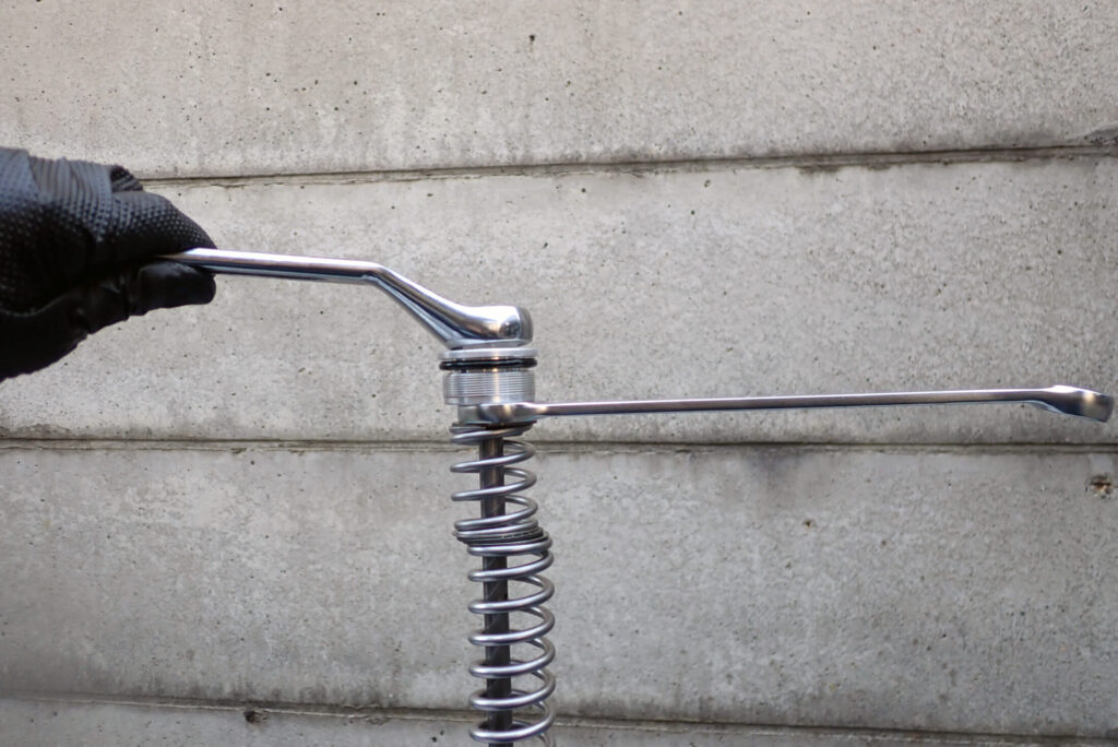 XR250 BAJAのフロントフォークメンテナンスの最終工程．トップボルトとロッドを締め付ける作業風景．