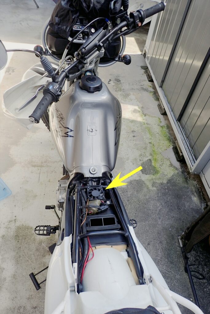 XR250およびXR BAJAのレギュレーターの位置を示した写真．シートを外し画像中に黄色矢印でその位置を指している．