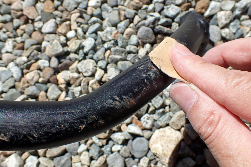 エンジンガードの古い塗装とサビを耐水ペーパーで削り落とす足付け作業の様子