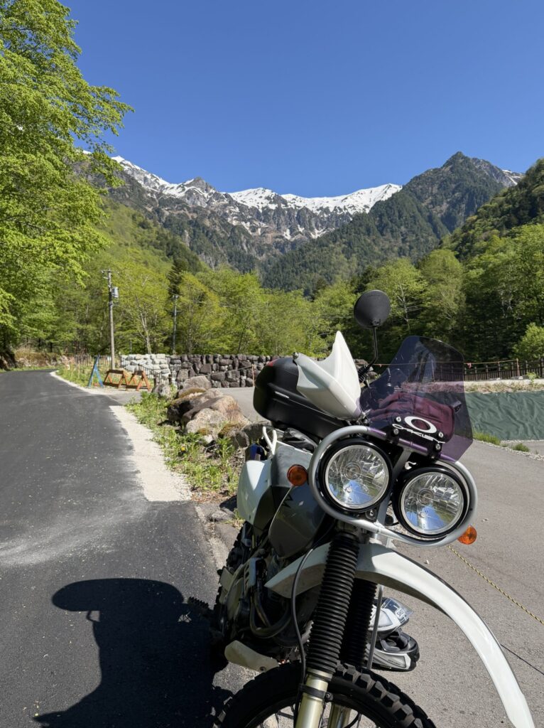 XR BAJAと残雪の残る穂高岳の写真。
