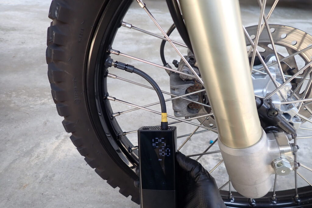 XR BAJAのフロントタイヤに、キジマのJP01を使って空気を入れている様子。