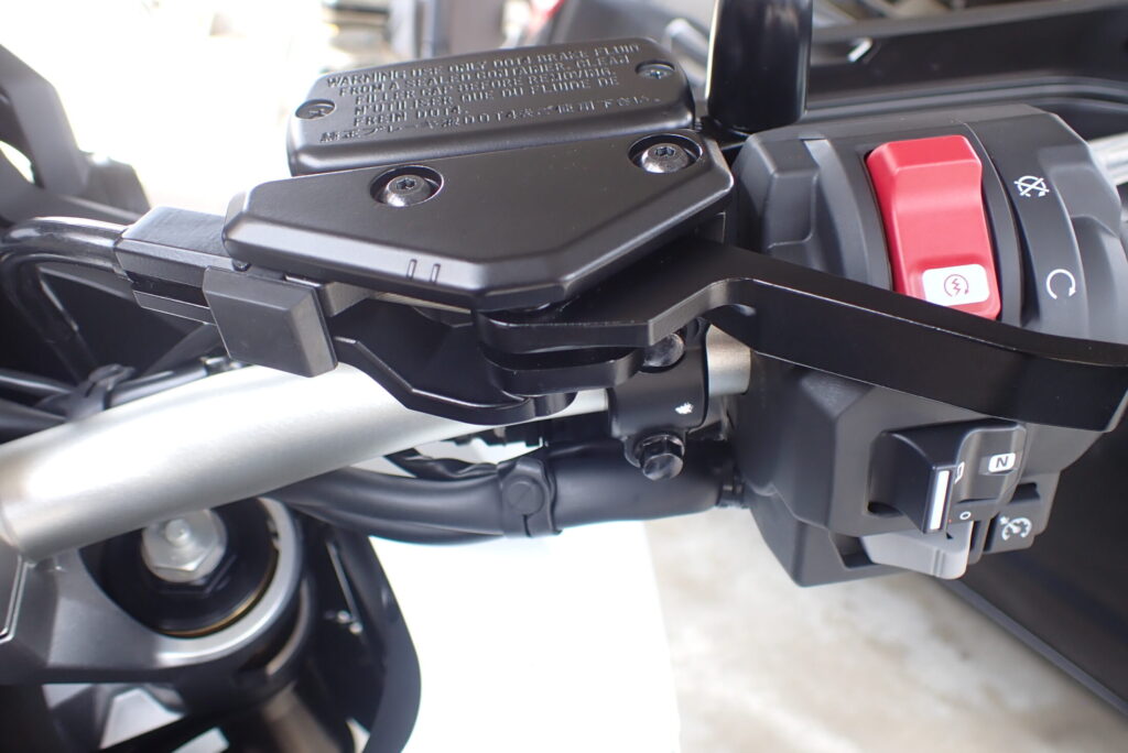 The parking brake lever mechanism installed on the right side of a Honda X-ADV 750 motorcycle handlebar.