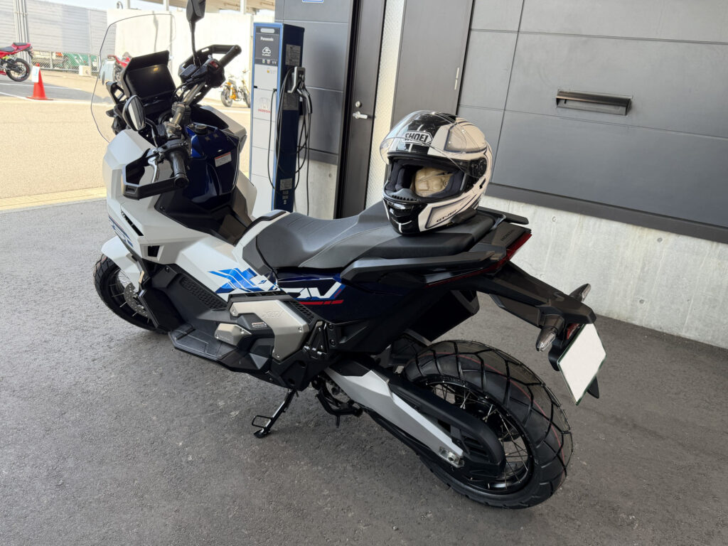 Rear left view of the Honda X-ADV 750 Special Edition, showcasing the rugged tubeless spoke wheel, adventure block tire, exhaust, and a SHOEI touring helmet.