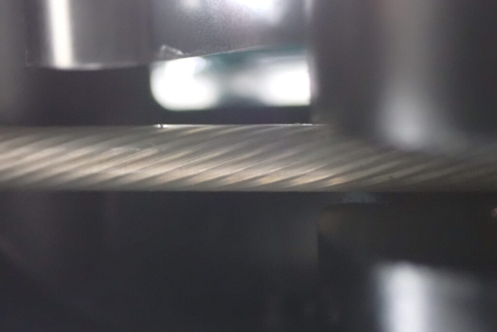 Extreme close-up of the Honda X-ADV parking brake inner wire, showing it perfectly protected by a transparent vinyl coating for rust prevention.