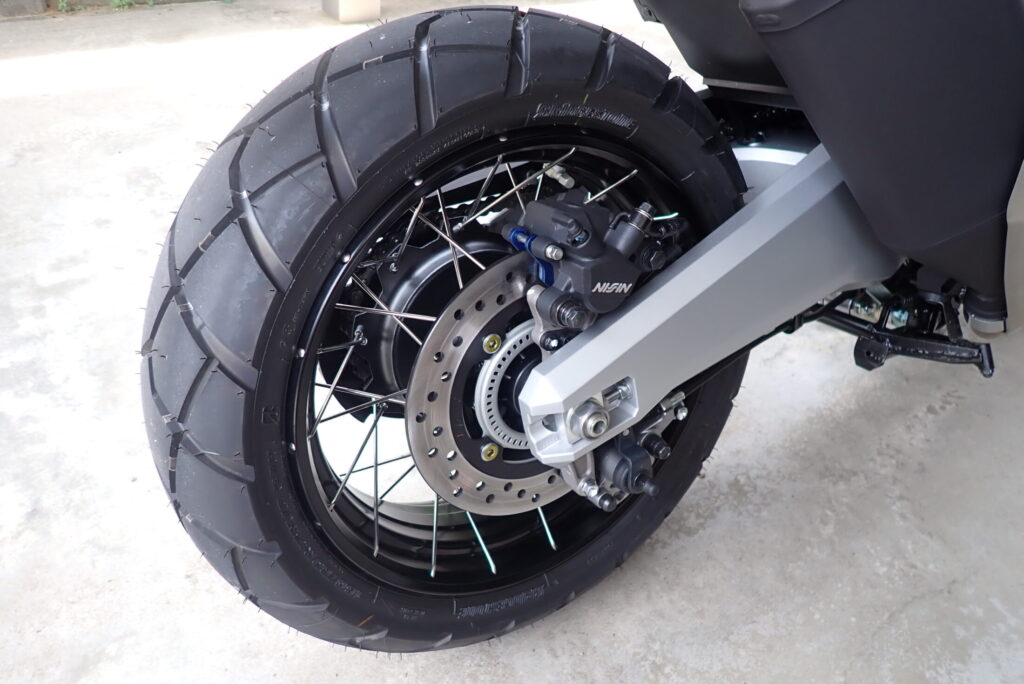 Rear 15-inch spoke wheel of a Honda X-ADV 750 showing the crowded area around the brake disc and swingarm.