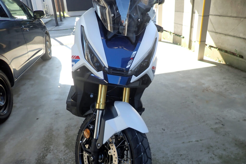 A brand-new tricolor Honda X-ADV Special Edition motorcycle parked inside a residential garage after delivery.