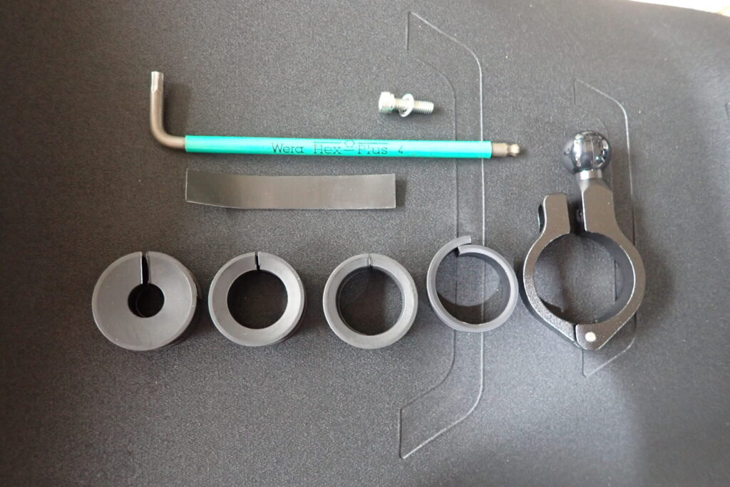 Kaedear motorcycle phone mount components and a green Wera hex key tool laid out on a black surface for installation.